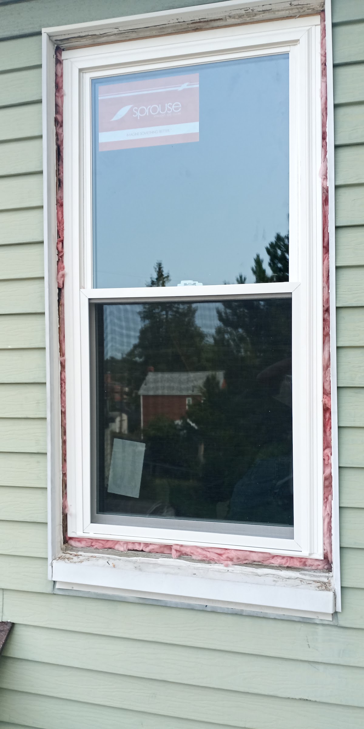 A newly installed double-hung window on a home's exterior siding